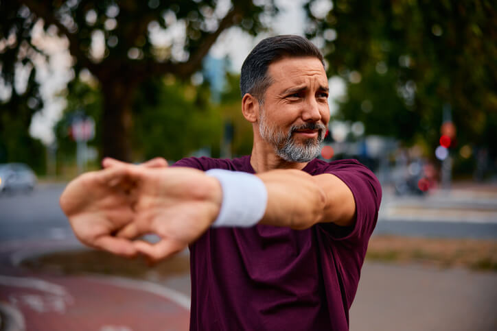 man stretching his shoulders 