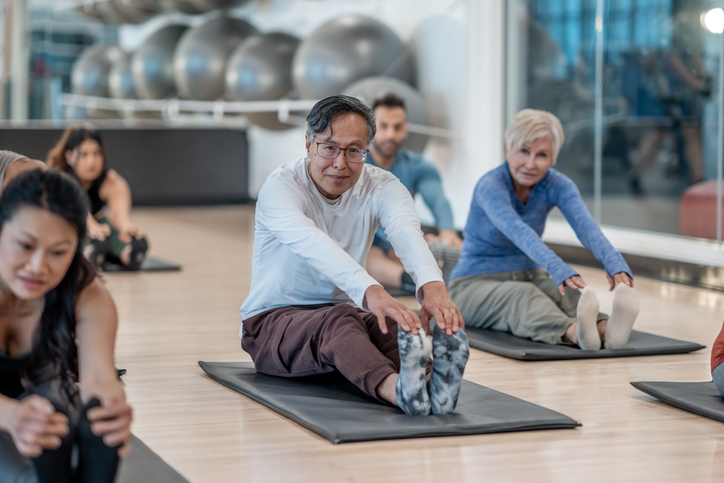 Group Fitness Class With Adults Stretching in an Exercise Setting